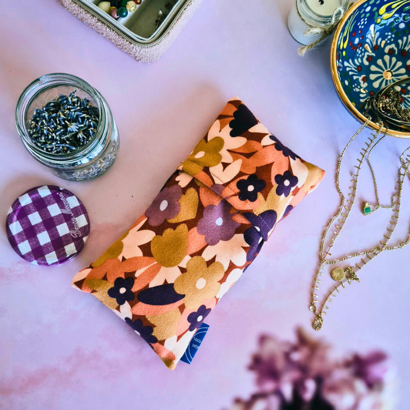 Bouillotte sèche “Juste pour toi” aux graines de lin avec housse florale colorée, coussin chauffant naturel déhoussable posé sur une table, accessoire cocooning bien-être