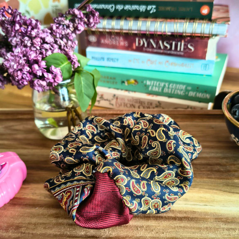 Chouchou Florence en tissu recyclé motif vintage posé devant des livres et des fleurs, accessoire cheveux écoresponsable pour lectrice