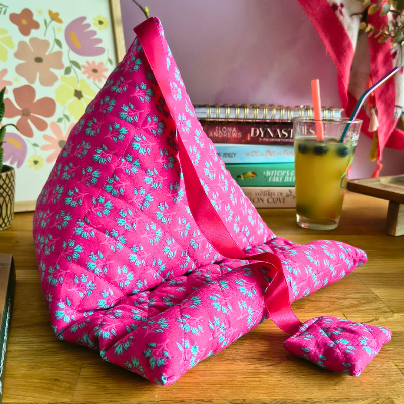 Coussin de livre berlingot rose floral fait main avec ruban marque-page, utilisé pour maintenir un livre ouvert et faciliter la lecture sans fatigue des poignets