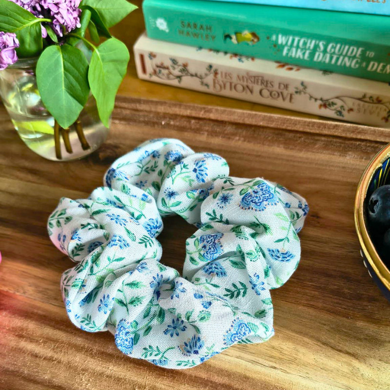 Chouchou Olivia en tissu recyclé motif élégant dans une ambiance lecture avec livres, accessoire cheveux écoresponsable pour lectrice